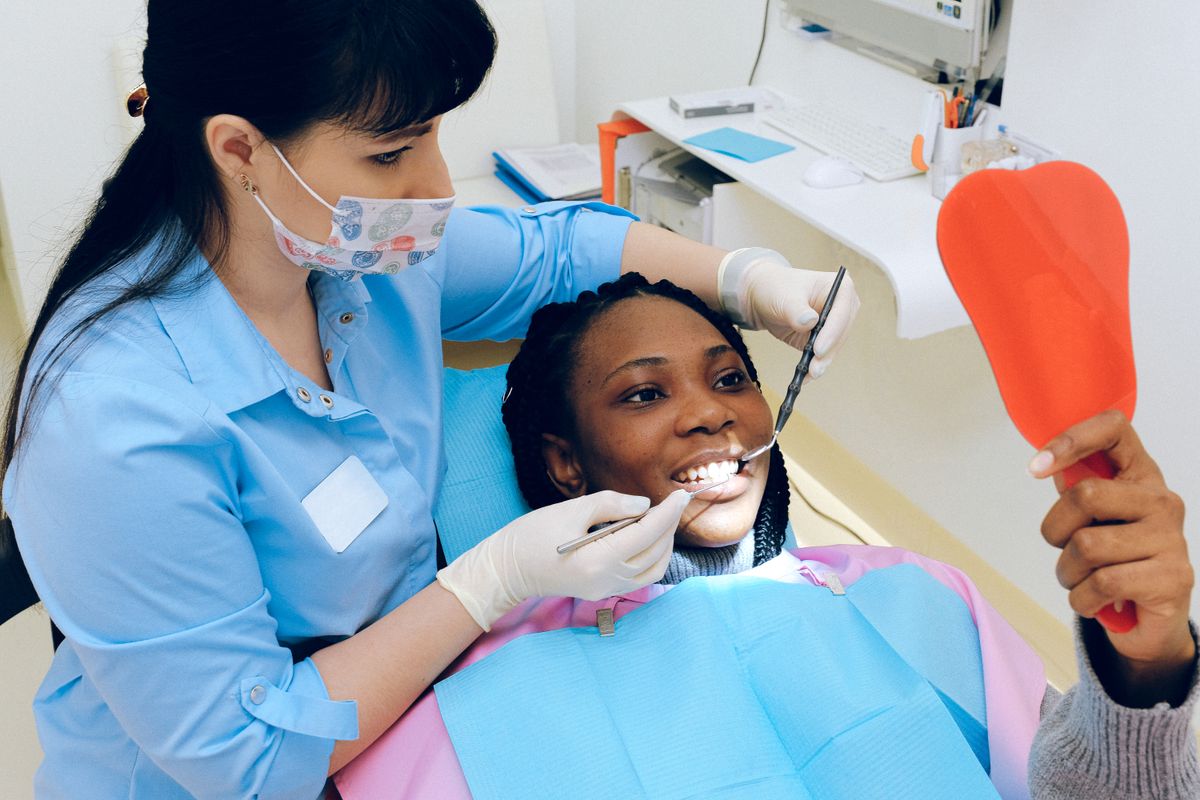 Hygienist treating a smiling patient during a dental cleaning